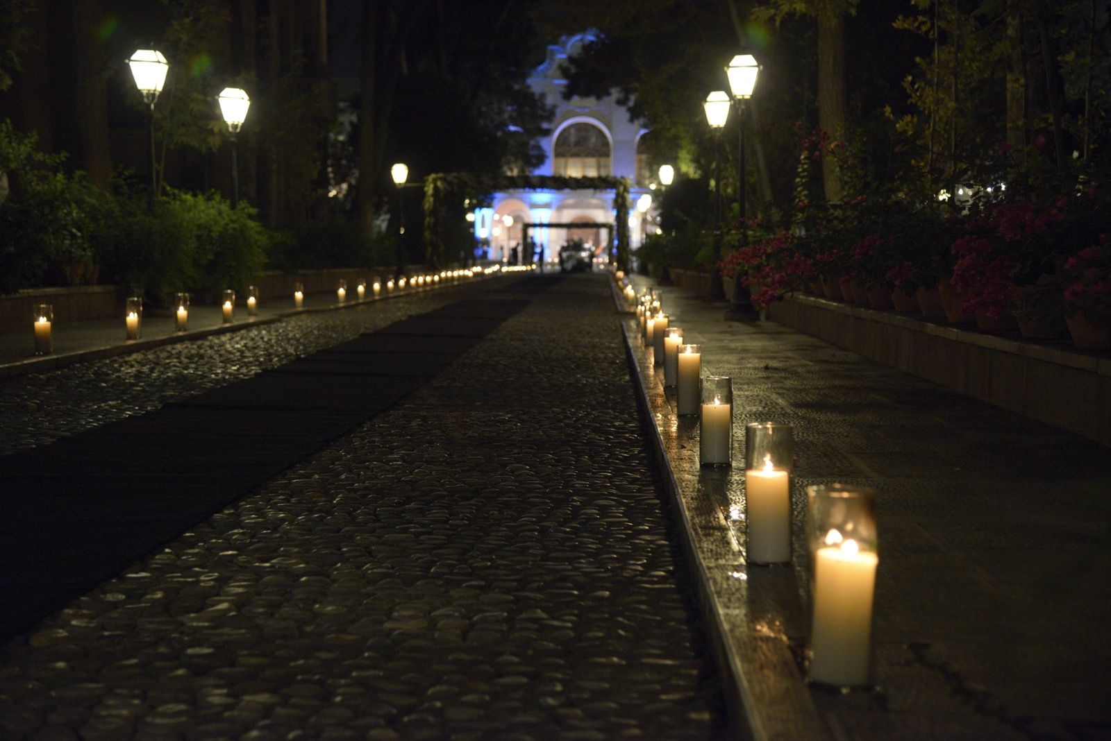 A candlelit private-event arrival in a Tehran garden
